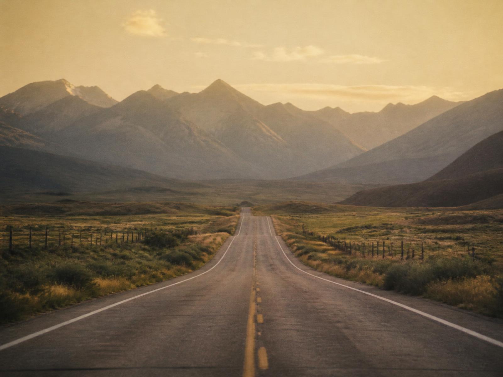 A quiet country road at golden hour, a symbolic path toward remembrance.